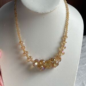 Peach glass AB coated bi-cone round facetted necklace.